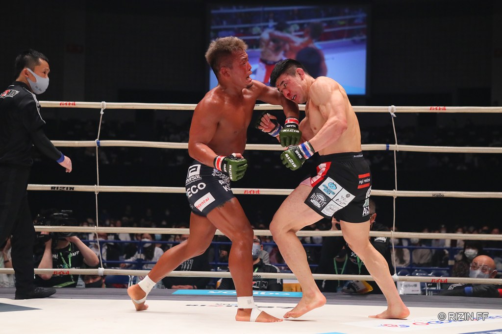 Koji Takeda throws a left hook at Takasuke Kume