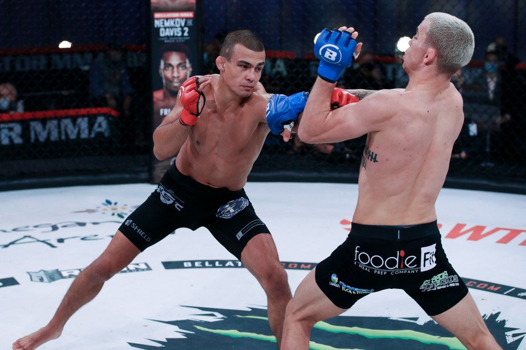 Adam Borics throws a left hand at Jeremy Kennedy, who has his arms up and is backing up from the punch.