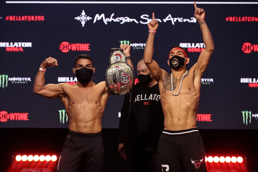 Patricio Pitbull and Emmanuel Sanchez both raise their arms while side by side at the Bellator 255 ceremonial weigh-ins.