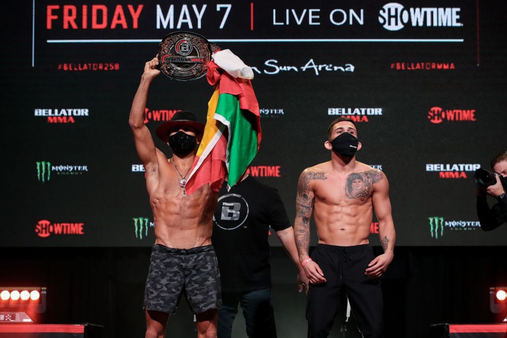 Juan Archuleta lifts his Bellator Bantamweight Championship up in the air while posing beside Sergio Pettis.