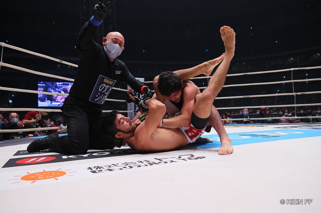 A referee motions to end a bout as Roberto Satoshi Souza applies a triangle choke on Tofiq Musayev