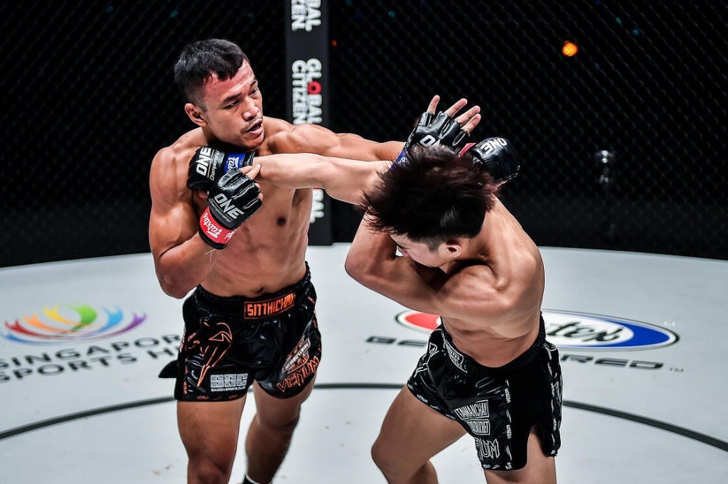 Sitthichai Sitsongpeenong throws a left cross at Tawanchai PK.Saenchaimuaythaigym