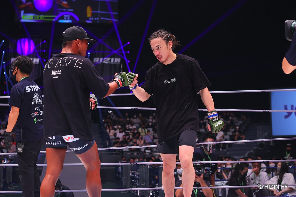 Yusuke Yachi bumps fists with Koji Takeda after their MMA fight.