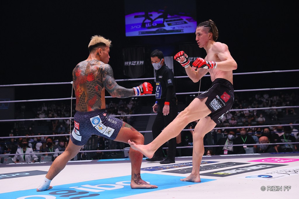 Naoki Inoue throws a leg kick to Kintaro