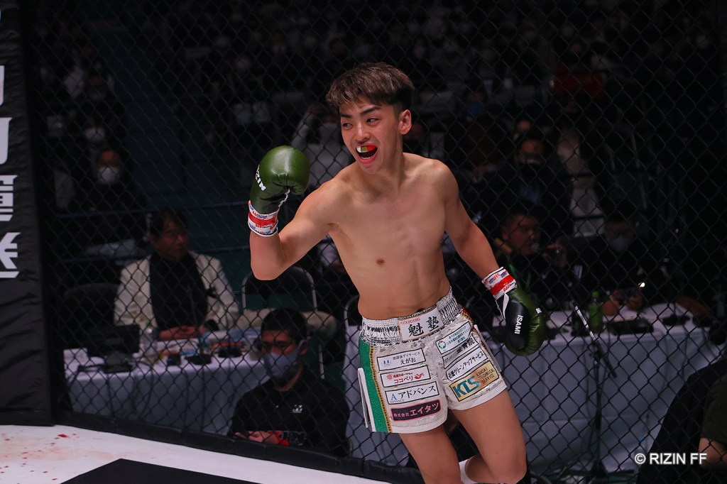 Jin Mandokoro runs around the RIZIN cage with a fist in the air.