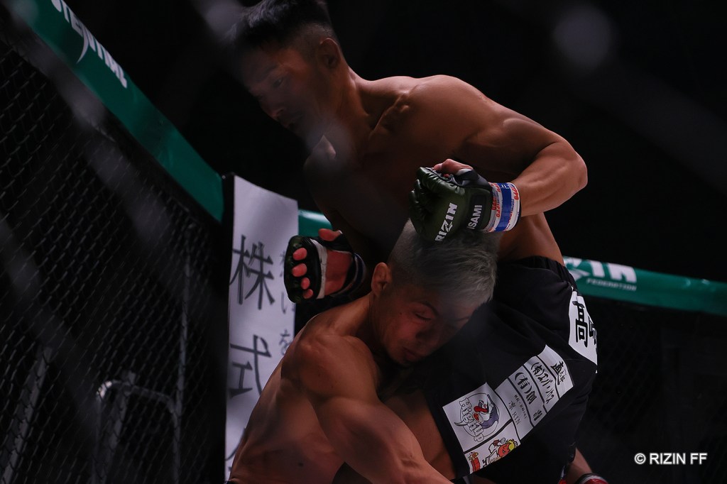 Daiki Lightyear lands a knee to the head of Makoto Kamaya in the RIZIN cage.