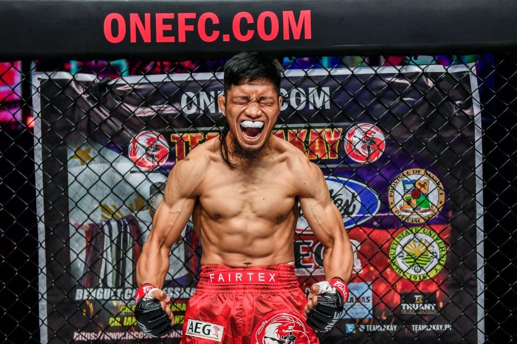 Lito Adiwang shouts and flexes while in the ONE Championship cage.