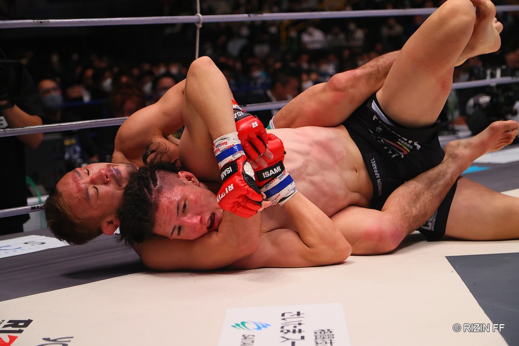 Hiromasa Ougikubo attempts a rear naked choke on Naoki Inoue.