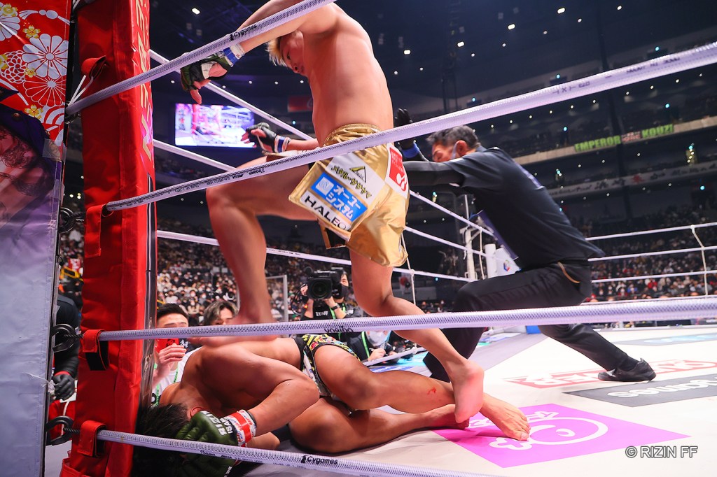 Shinobu Ota throws a stomp to a grounded Kazuma Sone.