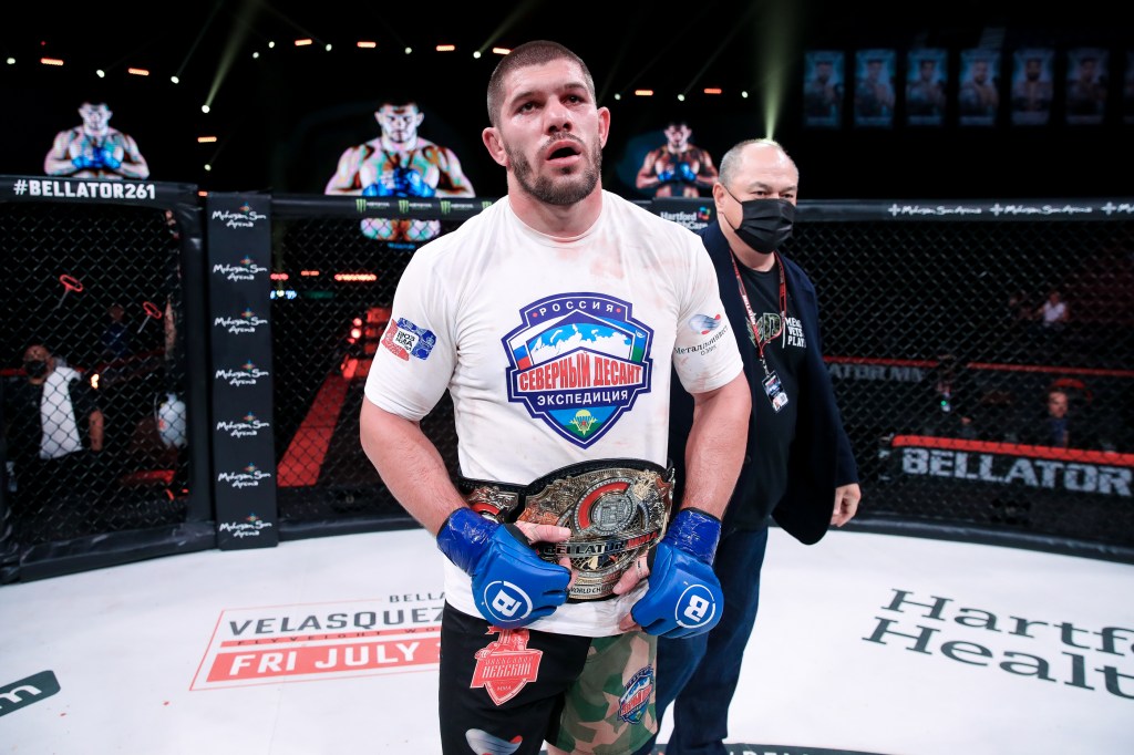 Valentin Moldavsky stands in the Bellator cage with a championship belt around his waist.