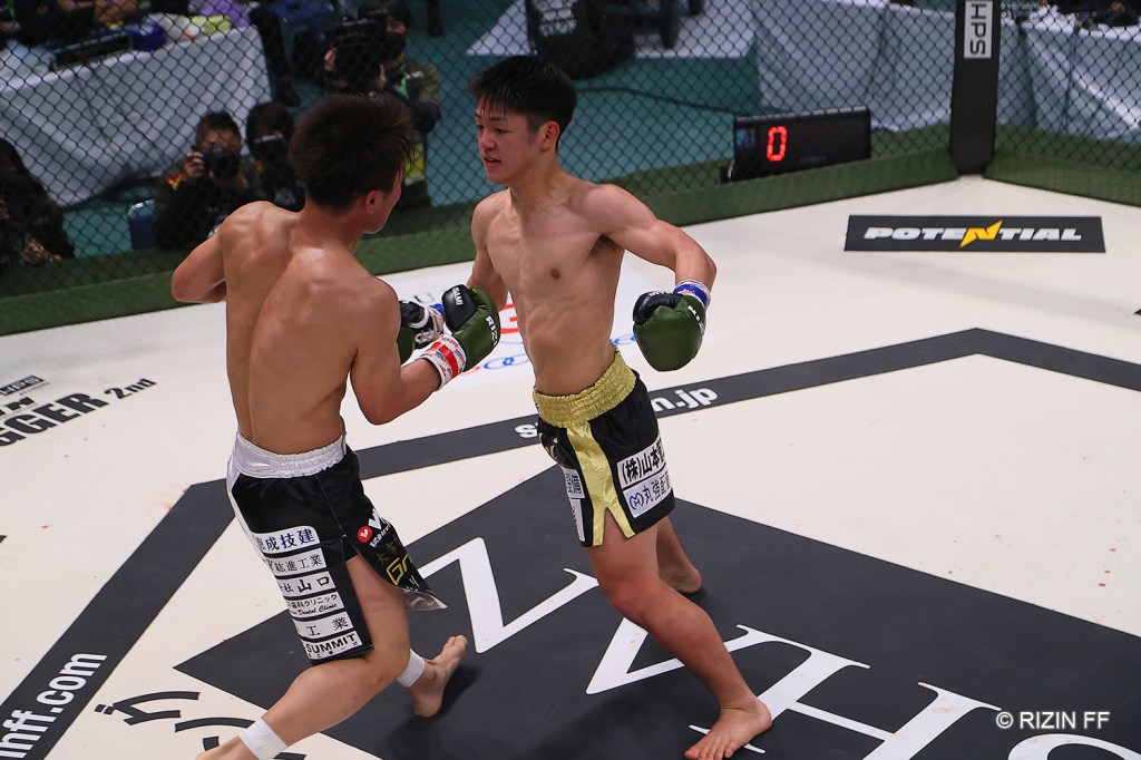 Taiki Matsui throws a left hook at Masanari in the RIZIN cage.