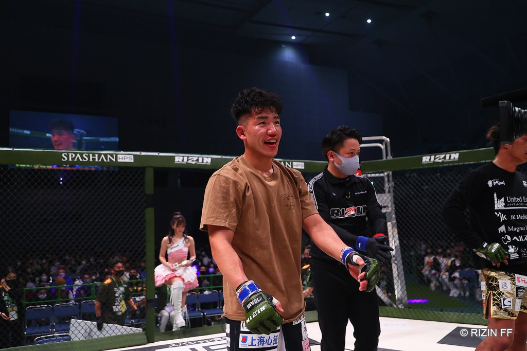 Kouki Nakagawa smiling while standing in the RIZIN cage.
