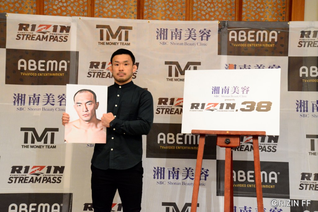 Hiromasa Ougikubo poses with a photo of Kim Soo-chul.