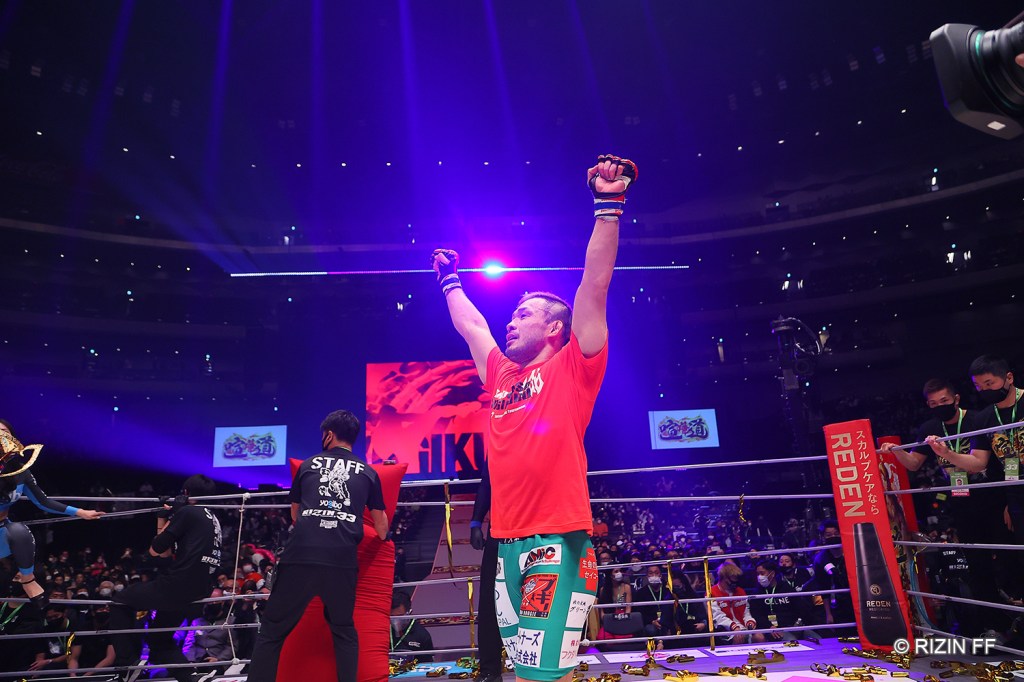 Hiromasa Ougikubo raises his arms in celebration while inside the RIZIN ring.