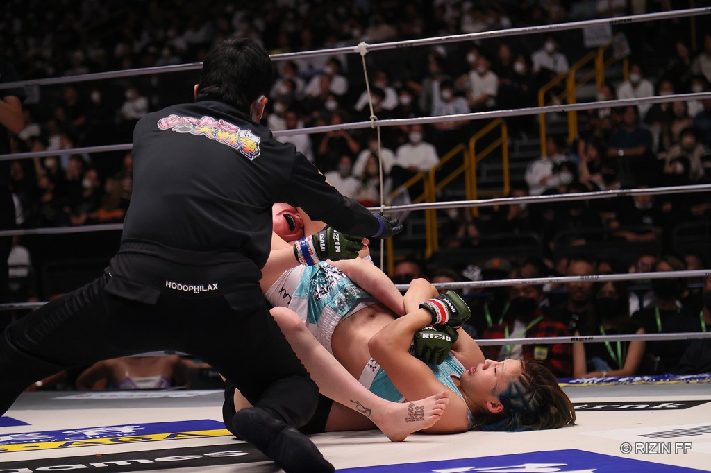 The referee stops a fight as Seika Izawa applies an armbar to Anastasiya Svetkivska.
